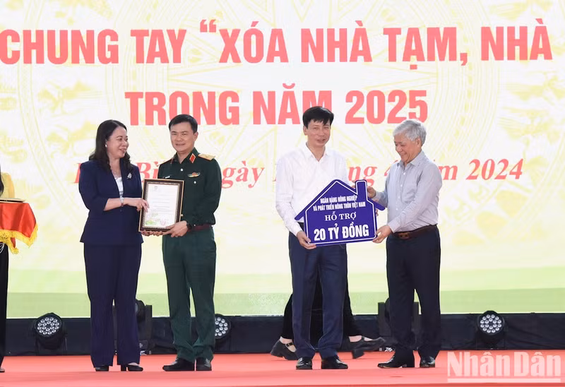 Do Van Chien recibe las donaciones de las empresas y organizaciones benéficas mientras Vo Thi Anh Xuan entrega cartas de gratitud a las entidades.