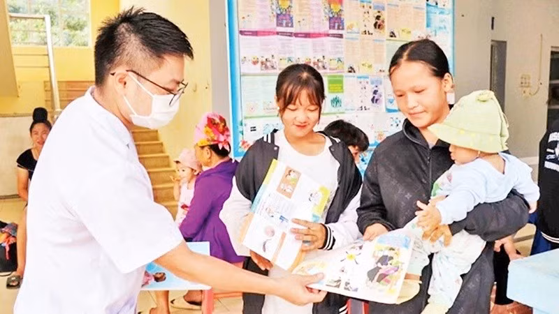 El personal médico de la comuna de Muong Cai, distrito de Song Ma, provincia de Son La, distribuye entre la población folletos propagandísticos sobre la planificación familiar. (Fotografía: Nhan Dan)