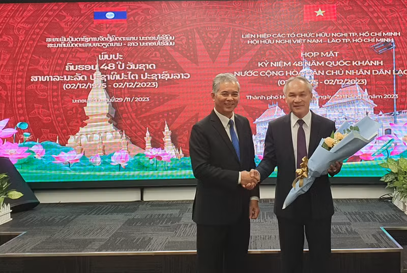 El presidente de la Asociación de Amistad Vietnam-Laos, Ngo Minh Chau, entrega flores para el cónsul laosiano en Ciudad Ho Chi Minh, Phonesy Bounmixay, con motivo del Día Nacional de Laos.