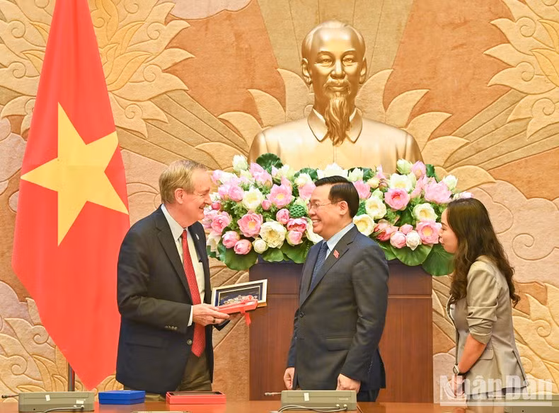 El presidente legislativo Vuong Dinh Hue entrega regalo conmemorativo a la delegación estadounidense.