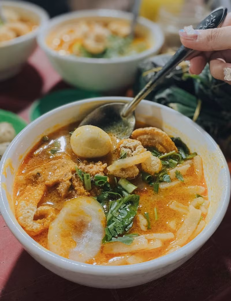 Banh Canh, un tipo de fideos de arroz, con pastel de cangrejo, chicharrones y huevo de codorniz.