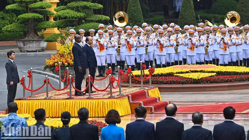 Los dos presidentes se paran el podio de honor escuchando los himnos de los dos países.