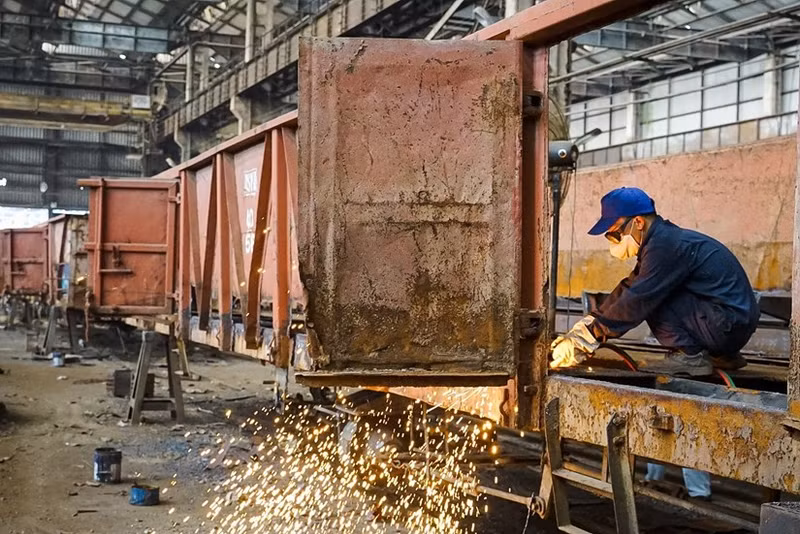 Los obreros realizan sus trabajos en la fábrica de trenes Gia Lam.