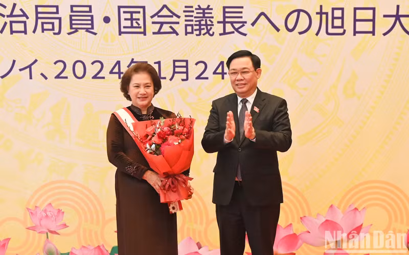 El presidente de la ANV, Vuong Dinh Hue, entrega flores para felicitar a Kim Ngan.