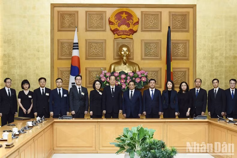 Los primeros ministros Pham Minh Chinh y Han Duck Soo y delegados en el encuentro.