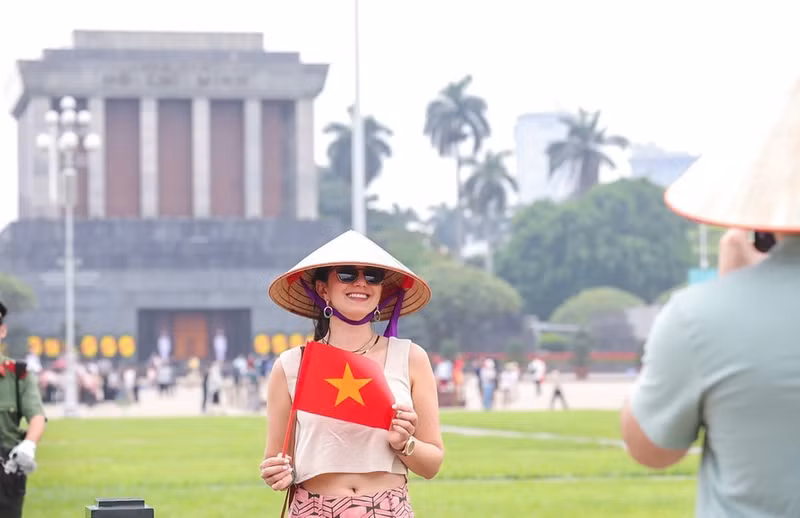 Visitantes extranjeros disfrutan tomándose fotos con la bandera vietnamita. (Foto: VNA) Visitantes extranjeros disfrutan tomándose fotos con la bandera vietnamita. (Foto: VNA)