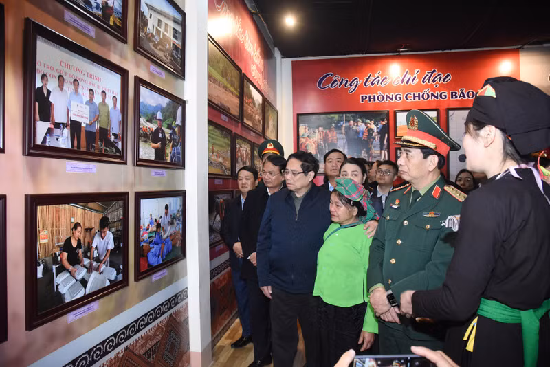 El primer ministro visita la exposición de fotografías y artefactos sobre las inundaciones en la Casa Cultural de la aldea Lang Nu.