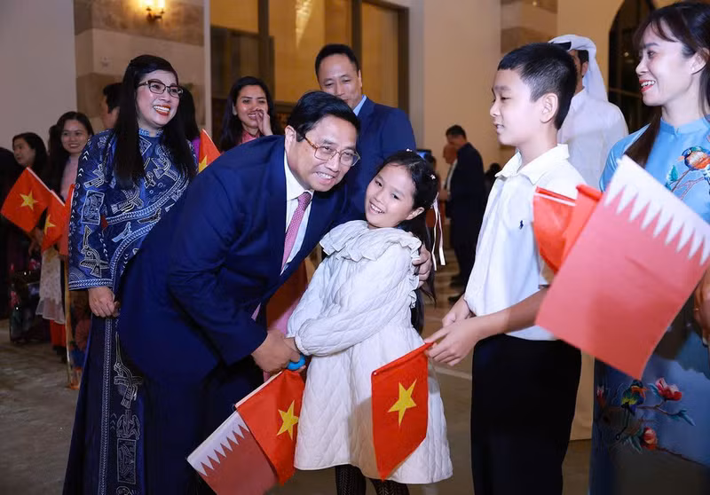 Funcionarios y empleados de la embajada y representantes de la comunidad vietnamita en Catar dan la bienvenida al primer ministro Pham Minh Chinh y a su esposa. (Foto: VNA)