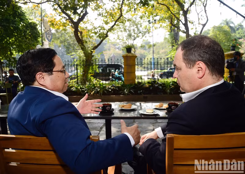 Minh Chinh y Roman Golovchenko disfrutan de un café y admiran las calles de Hanói.
