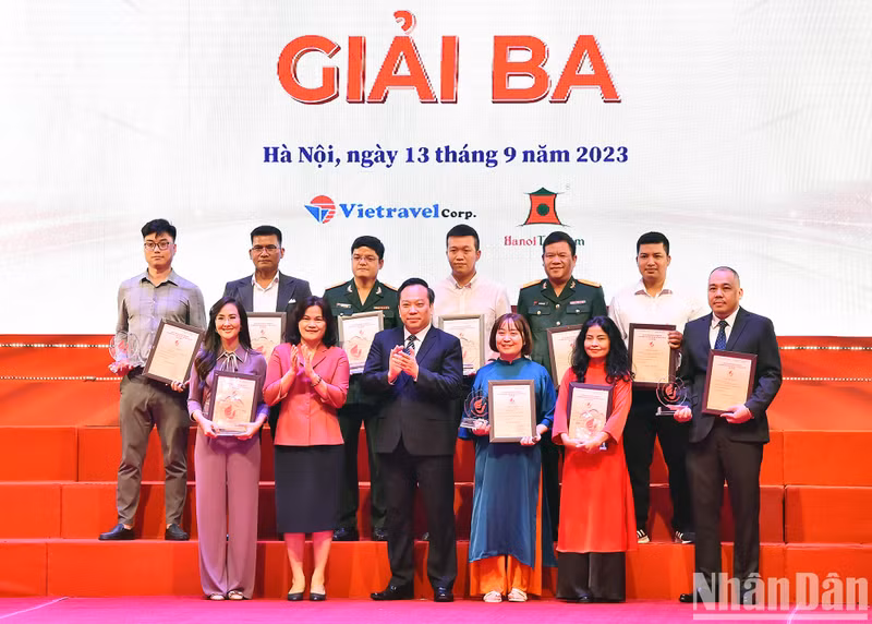 El vicesecretario del Comité partidista en bloque de órganos centrales, Do Viet Ha, y la subdirectora general de la Agencia Vietnamita de Noticias, Nguyen Thi Su, entregan el tercer premio a los concursantes.