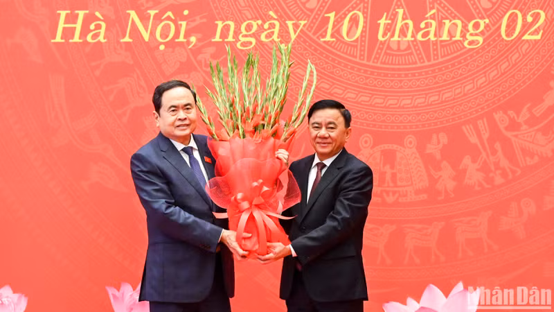 El miembro permanente del Secretariado del PCV, Tran Cam Tu, entrega flores para felicitar al secretario del Comité partidista de la ANV y presidente de este órgano, Tran Thanh Man.