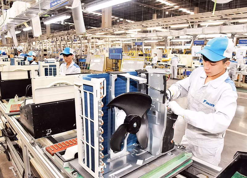 El gobierno implementa un sistema de soluciones para resolver las dificultades de las empresas. En la foto: Obreros de la Sociedad Anónima Daikin ensamblan acondicionadores de aire. (Fotografía: Dong Minh)