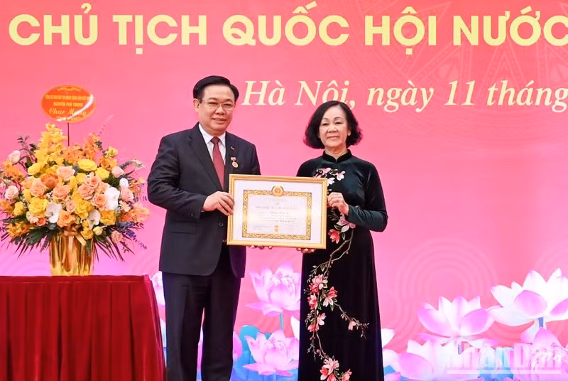 La miembro del Buró Político y permanente del Secretariado del Comité Central del PCV y jefa de su Comisión de Organización, Truong Thi Mai, entrega la insignia a Vuong Dinh Hue. 