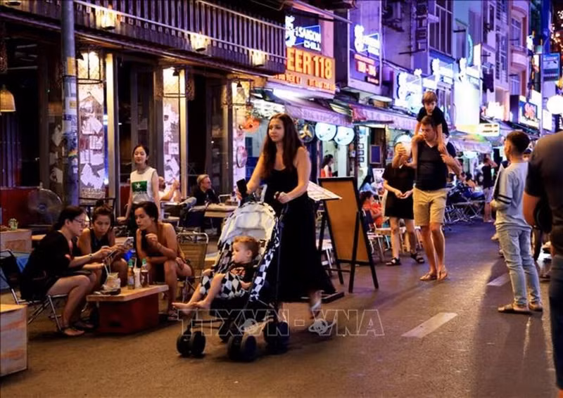 Turistas extranjeros paseando por la calle Bui Vien, Distrito 1, Ciudad Ho Chi Minh. (Foto: VNA)