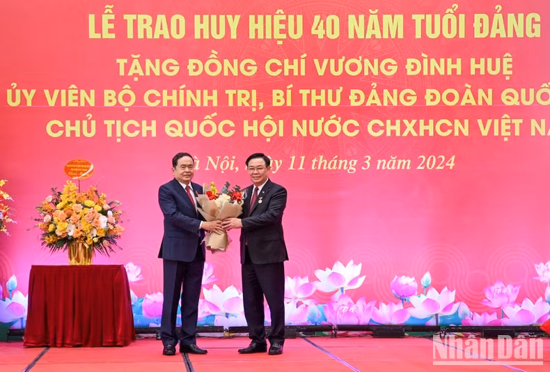 El vicepresidente permanente de la AN, Tran Thanh Man, entrega flores para felicitar a Dinh Hue.