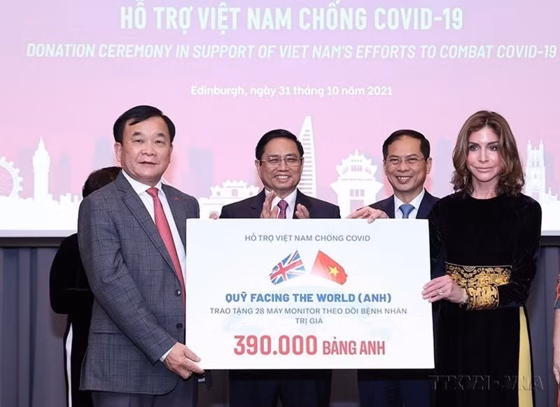 El primer ministro Pham Minh Chinh presenció la entrega de donaciones para apoyar a Vietnam en la lucha contra la pandemia de COVID-19 durante su visita de trabajo a Reino Unido (2021). (Foto: VNA)