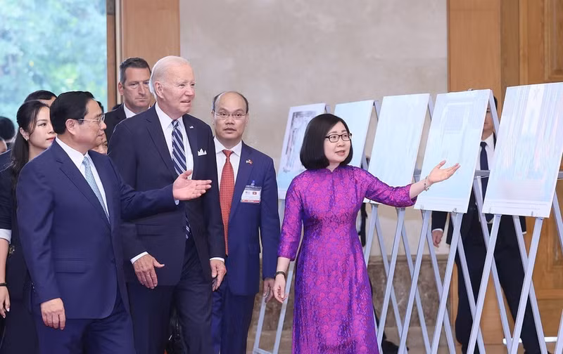 La subdirectora general de la Agencia Vietnamita de Noticias (VNA), Doan Thi Tuyet Nhung, presenta obras fotográficas al primer ministro Pham Minh Chinh y al presidente estadounidense Joe Biden, en una exposición realizada por la VNA (11 de septiembre de 2023). (Foto: VNA)