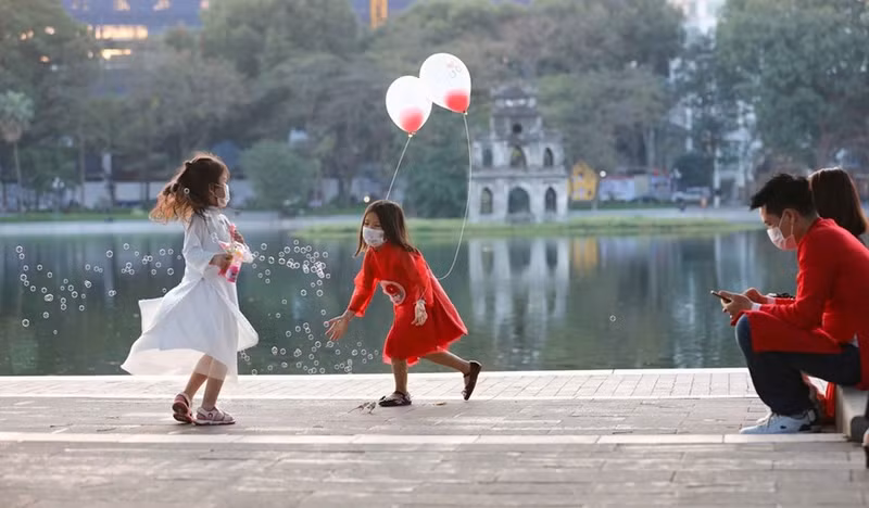 Los padres y sus hijos pasean por el lago Guom. (Fuente: VNA)