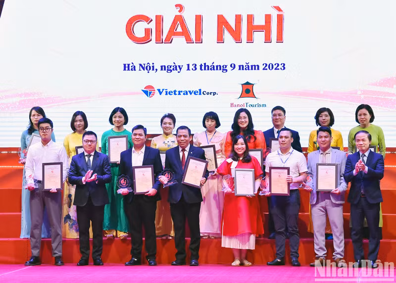 El subjefe permanente de la Comisión para la Movilización de Masas del Comité Central del PCV, Pham Tat Thang y Le Quoc Minh, presidente-editor de Nhan Dan, subjefe de la Comisión de Comunicación y Educación del PCV y presidente de la Asociación de Periodistas del país, otorgan el segundo premio a los ganadores.
