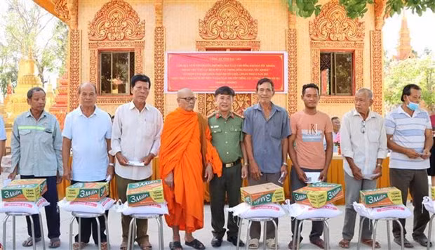El primer coronel Le Thanh Hung entrega obsequios a los pobladores del distrito de Vinh Loi. (Foto: VNA) 