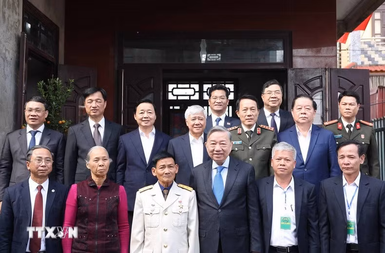 To Lam y los delegados con la familia del Héroe de las Fuerzas Armadas Populares, Dinh Quoc Phong. (Foto: VNA)