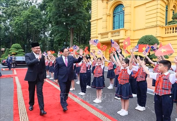 El primer ministro vietnamita, Pham Minh Chinh, y su homólogo malasio, Anwar Ibrahim, en la ceremonia de bienvenida (Foto: VNA)