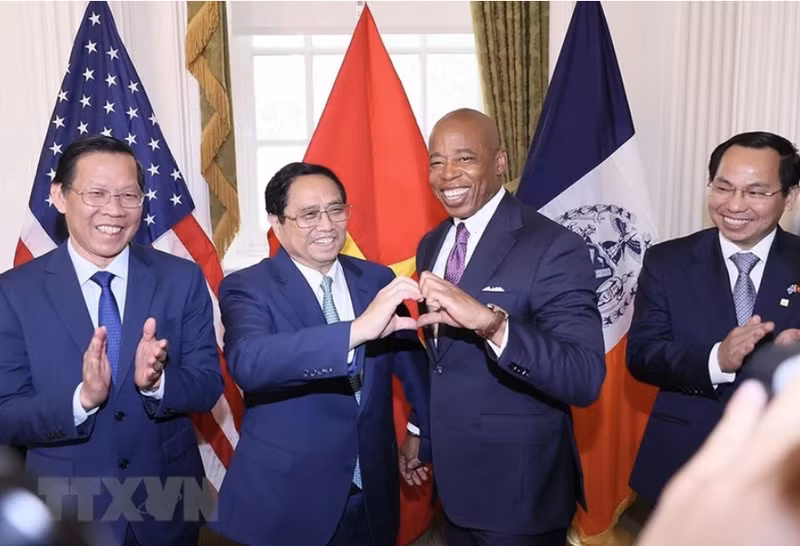 Minh Chinh y Eric Adams. (Foto: VNA)
