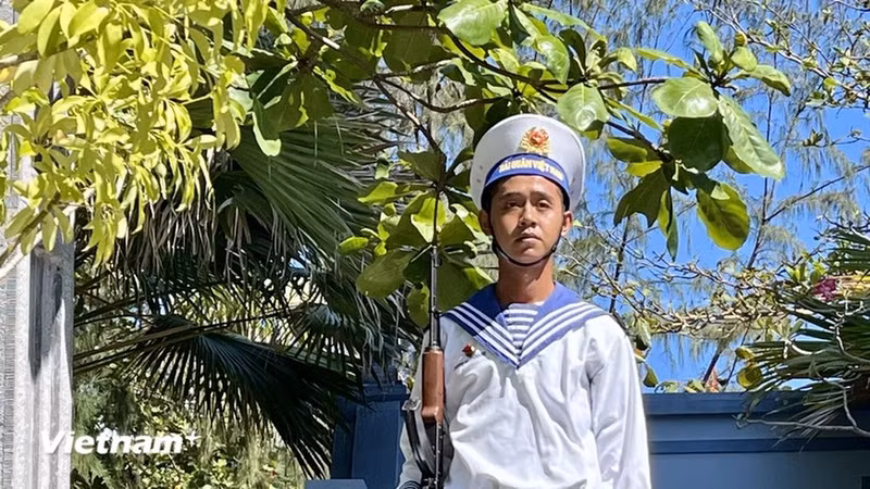 El joven soldado sostiene firmemente su arma para proteger la sagrada soberanía nacional en el mar y las islas.
