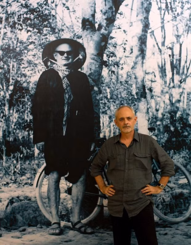 George Burchett posa junto a un retrato de su padre, el periodista Wilfred Burchett, en el Museo del Presidente Ho Chi Minh. (Fotografía: VNA)