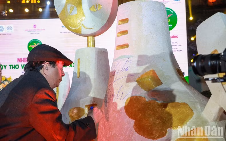 Delegados estampan su firma en la escultura del gato.