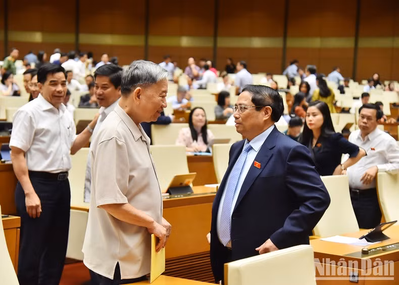 El primer ministro Pham Minh Chinh y el ministro de Seguridad Pública To Lam debaten al margen de la reunión.