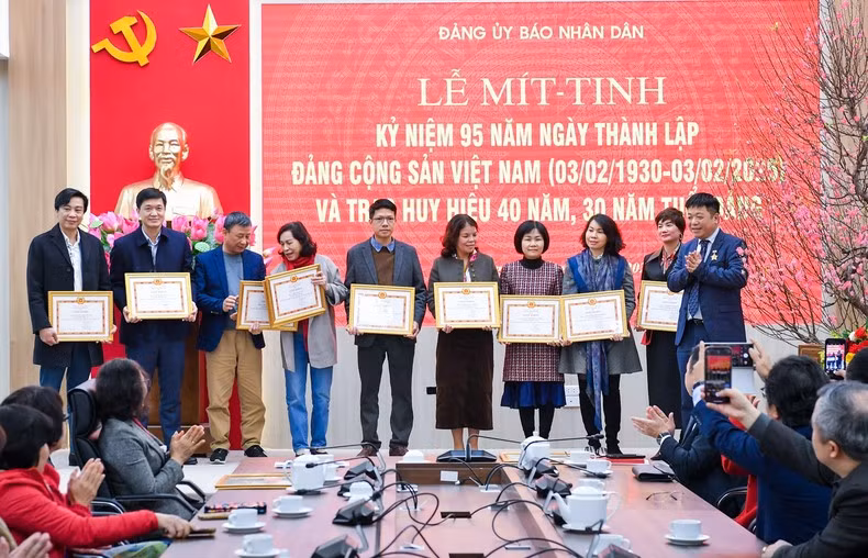Que Dinh Nguyen, redactor subjefe del periódico Nhan Dan, entrega Certificados de Mérito a los sobresalientes militantes.