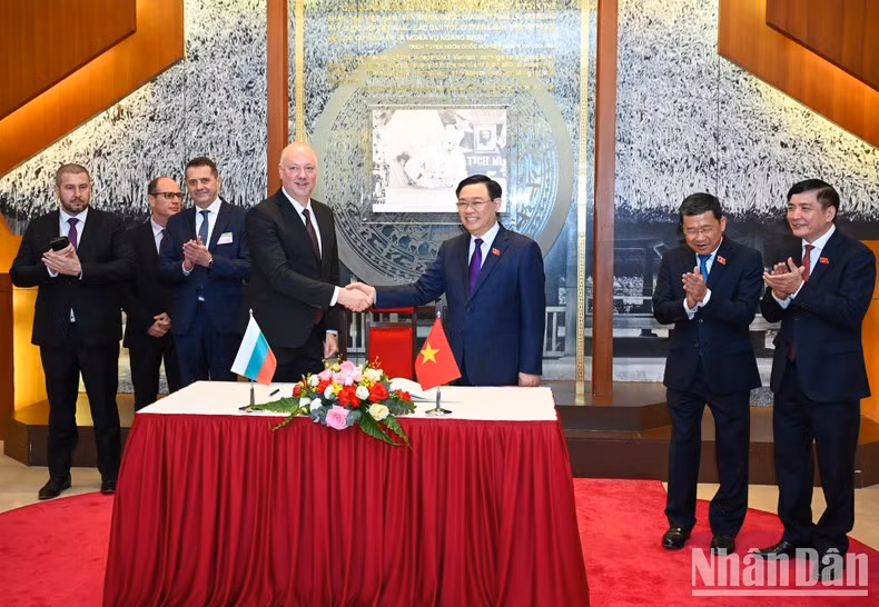 Rossen Dimitrov Jeliazkov firma el Libro de Recuerdos en la casa tradicional de la AN de Vietnam.