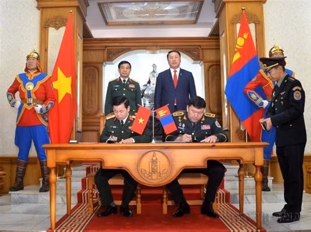 El Ministro de Defensa Nacional, Phan Van Giang, y su homólogo mongol, Gürsediin Saikhanbayar, presenciaron la ceremonia de firma del Acuerdo sobre el intercambio de delegaciones entre las dos carteras (2023). (Foto:VNA)