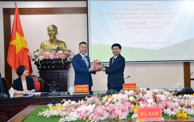 El presidente del Comité Popular de Ha Nam, Truong Quoc Huy (derecha), entrega un regalo al gobernador de la prefectura de Shiga, Mikazuki Taizo. (Foto: VNA)