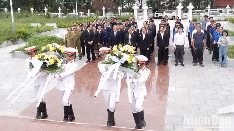 Los asistentes ofrecen coronas de flores en la reliquia de la alianza Laos-Vietnam. (Foto: Hai Tien)