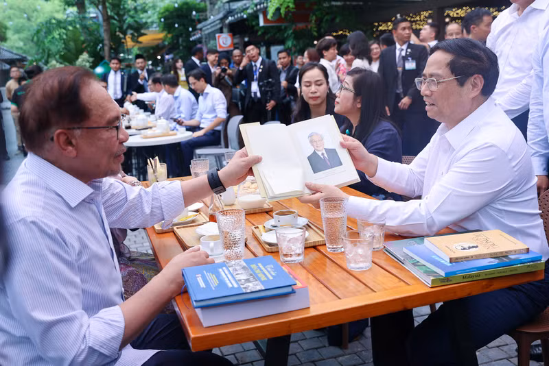 El primer ministro de Vietnam,Pham Minh Chinh, y su homólogo malasio, Anwar Ibrahim, junto con sus respectivas esposas, disfrutan el café vietnamita. (Foto: VNA)