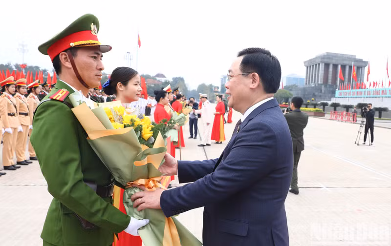 El titular del Parlamento vietnamita, Vuong Dinh Hue, entrega flores a los representantes de las delegaciones.