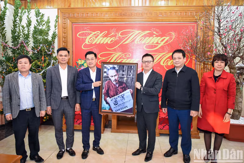 Le Quoc Minh, presidente-editor del periódico Nhan Dan, entrega una foto del Tío Ho a los oficiales y soldados de la entidad militar.