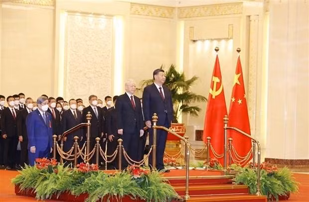 El secretario general del Partido Comunista de Vietnam, Nguyen Phu Trong, y el máximo dirigente partidista y presidente de China, Xi Jinping, escuchan los himnos nacionales de sus países. (Fotografía: VNA)