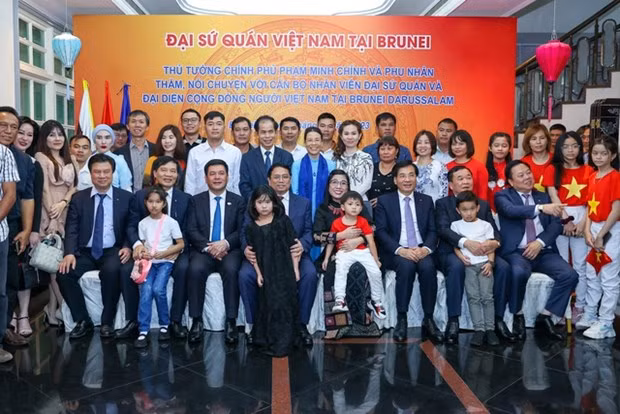 El primer ministro de Vietnam, Pham Minh Chinh, y representantes de la comunidad de compatriotas residentes en Brunéi. (Fotografía: VNA)