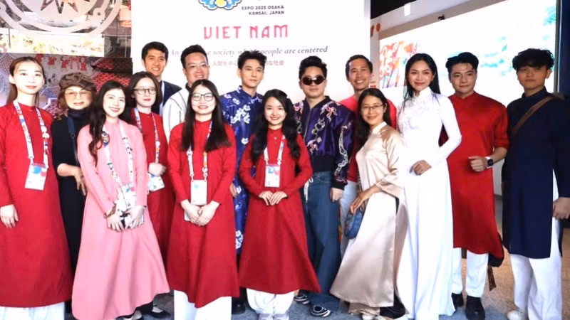 Los artistas vietnamitas se toman fotos en el pabellón de su país en la EXPO 2025. (Fotografía: Nhan Dan)