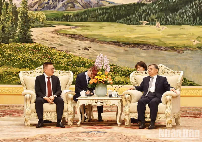 Reunión entre el presidente-editor de Nhan Dan, Le Quoc Minh (izquierda), y Li Shulei, miembro del Buró Político del Comité Central del PCCh y jefe de su Departamento de Publicidad. (Fotografía: Nhan Dan)