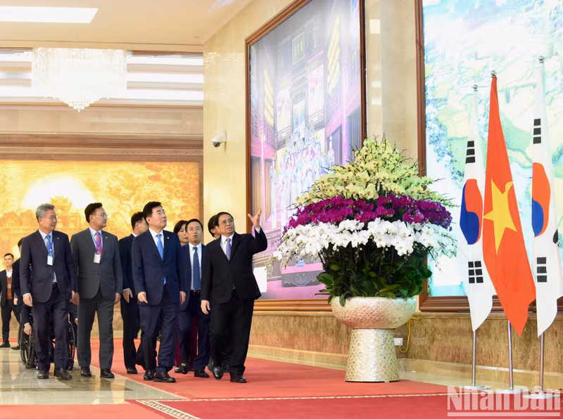 El jefe de Gobierno enseña a los visitantes imágenes sobre el país y la gente vietnamitas.
