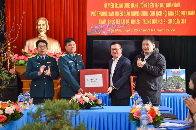 Quoc Minh, también miembro del Comité Central del Partido Comunista, subjefe de su Comisión de Comunicación y Educación y presidente de la Asociación nacional de Periodistas, entrega regalos por el Tet a oficiales y soldados de la Compañía.