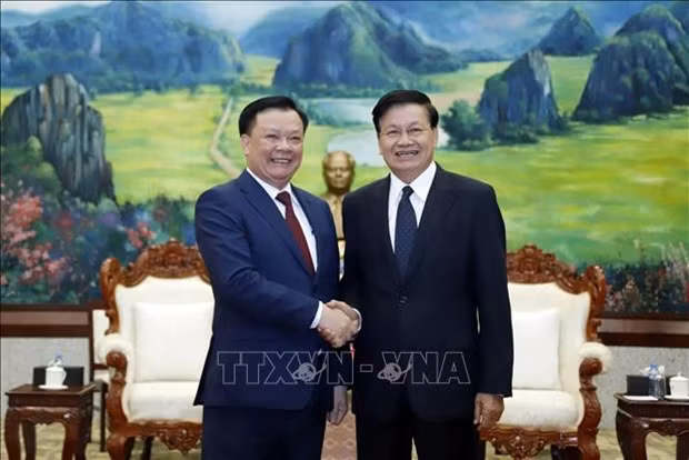El secretario general del Partido Popular Revolucionario y presidente de Laos, Thongloun Sisoulith, recibe al secretario del Comité partidista en Hanói, Dinh Tien Dung. (Fotografía: VNA)