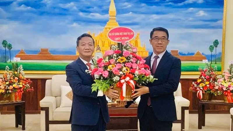 El embajador de Vietnam en Laos, Nguyen Minh Tam, entrega flores del secretario general del PCV, To Lam, al jefe interino de la Comisión de Relaciones Exteriores del Comité Central del PPRL, Bounleua Phandanouvong, con motivo del 70 aniversario de la fundación del PPRL. (Fotografía: Nhan Dan)