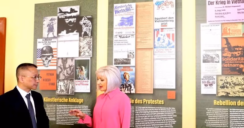 Claudia Opitz, uno de los organizadores de la exposición, presenta con el ministro consejero Chu Tuan Duc de la Embajada de Vietnam en Alemania sobre la exhibición de fotos y pinturas. (Fotografía: VNA)