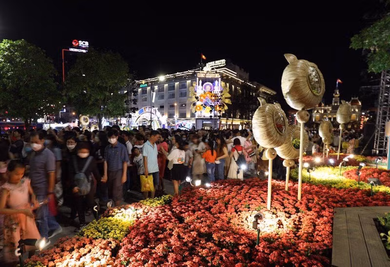 Miles de personas afluyen a la calle peatonal de Nguyen Hue para tomar fotos junto con arreglos florales allí. (Fotografía: kinhtedothi.vn)