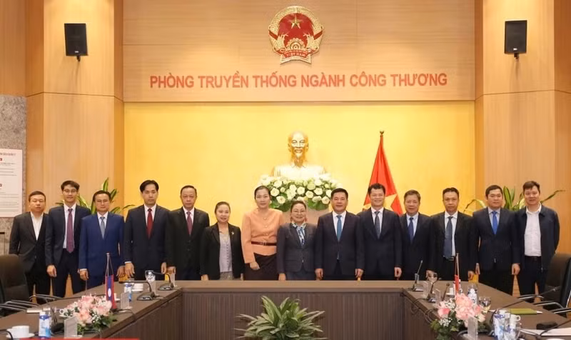El ministro de Industria y Comercio, Nguyen Hong Dien (sexto desde la derecha), y la embajadora de Laos en Vietnam, Khamphao Ernthavanh (séptima desde la derecha), mantienen una sesión de trabajo. (Fotografía: tapchicongthuong.vn)